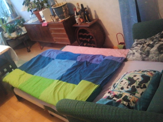 En bred säng och vinskåpet inom räckhåll.