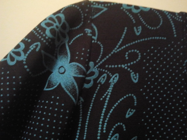 Svart med blåskimrande mönster.