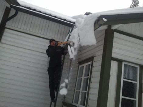 Guuben hjälper snön ner från taket.