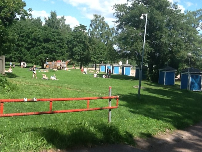 Sol över badstrandens gräsmatta.