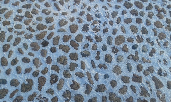 Kullerstensbeläggning på kyrkoparkeringen.