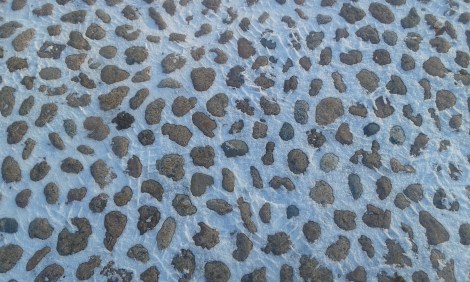 Kullerstensbeläggning på kyrkoparkeringen.