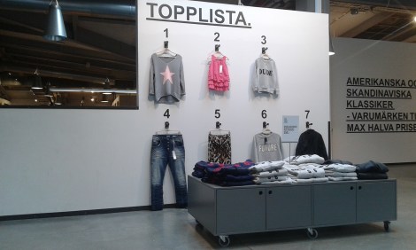 I en stor hall säljs märkeskläder på outlet.