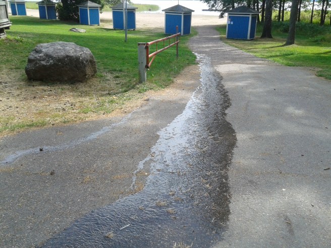En liten flod rinner från terrassområdet mot stranden.