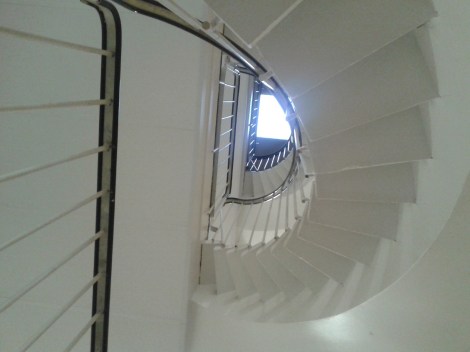 Står på bottenvåning i huset där jag bor och kikar upp mot takfönstret i tredje våningen.