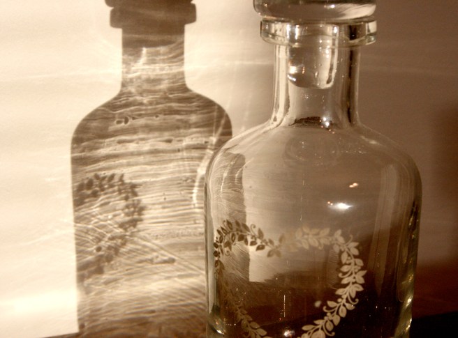 Sol, en glasflaska jag fått av min syster, skuggor, betongvägg = vackert.