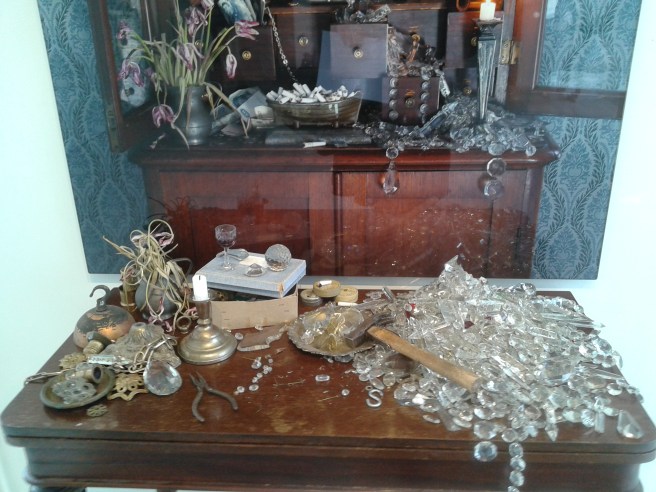 Framför tavlan finns ett bord med diverse prylar.