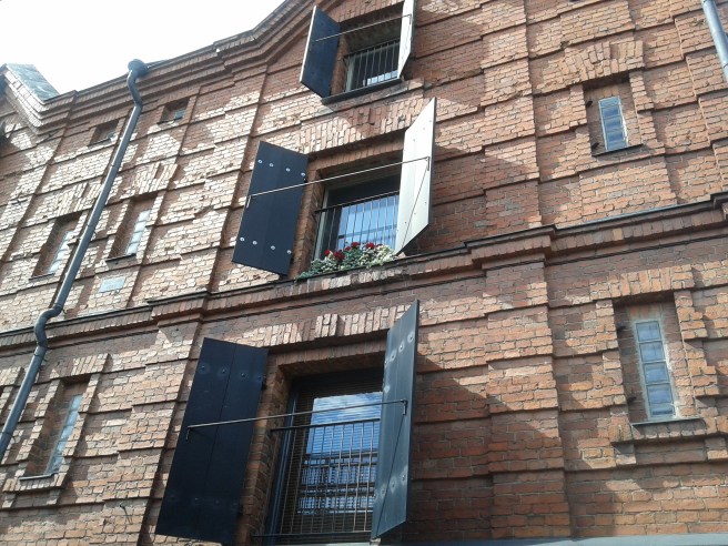 Fasaden mot söder alldeles intill en av broarna som går över ån.