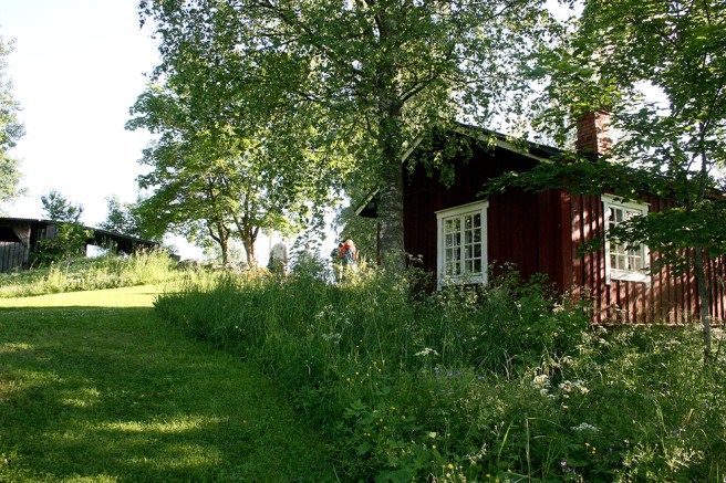 En annan stuga på Postbacken. Till vänster syns en del av byggnaden där scenen och publikens sittplatser finns.