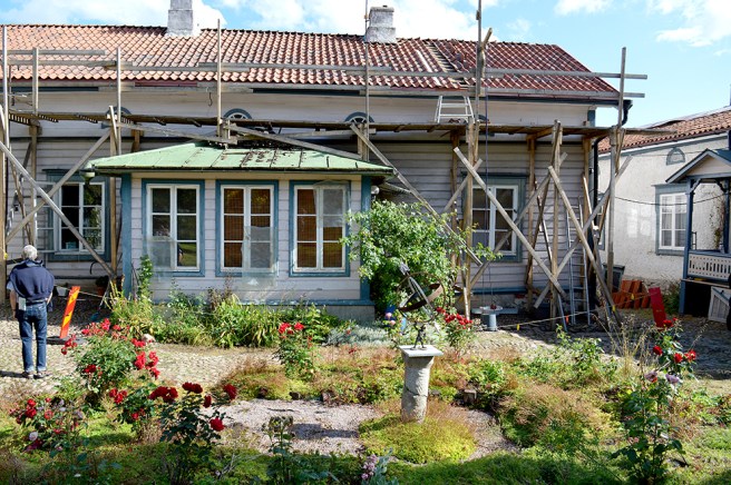 Otroligt vacker och lummig gård med kullerstensbeläggning.