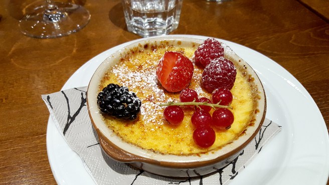 Créme brulée med färska bär som efterrätt.