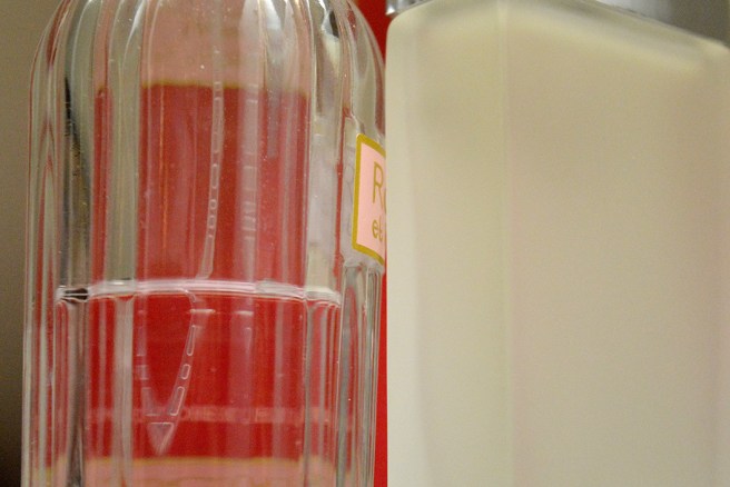 En närbild av två flaskor med parfymernas namn nästan osynliga.