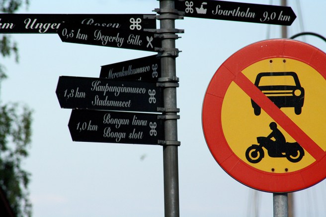 Gillar kontrasten mellan de svartvita små skyltarna och det granna förbudsmärket.