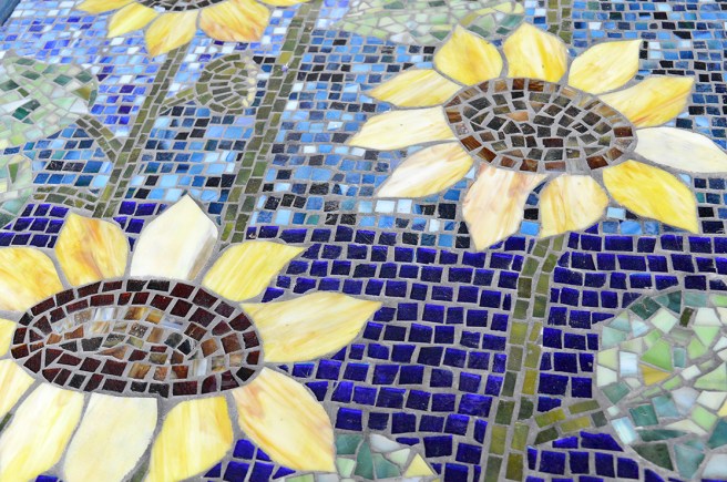 Mosaikarbeten blir man glad av, och blommor likaså!