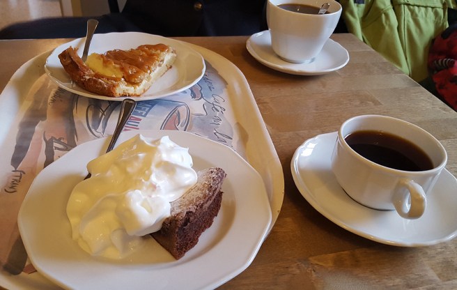 Kladdkaka med LITE vispgrädde, och äppelkaka där bakom.