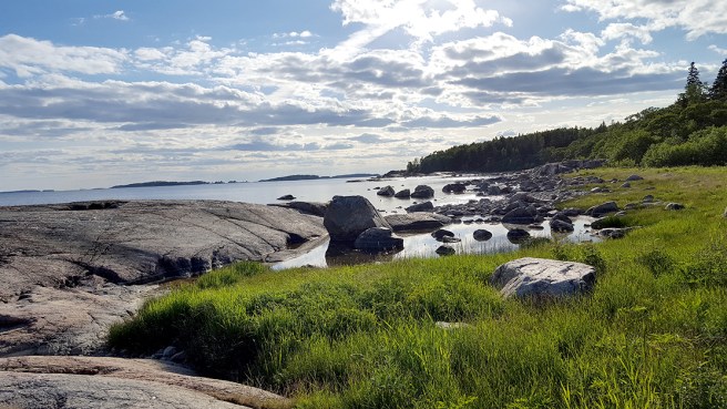 Klippor och strandstenar i motljus måndagskvällen den 6 juni på Fagerö i Sibbo.