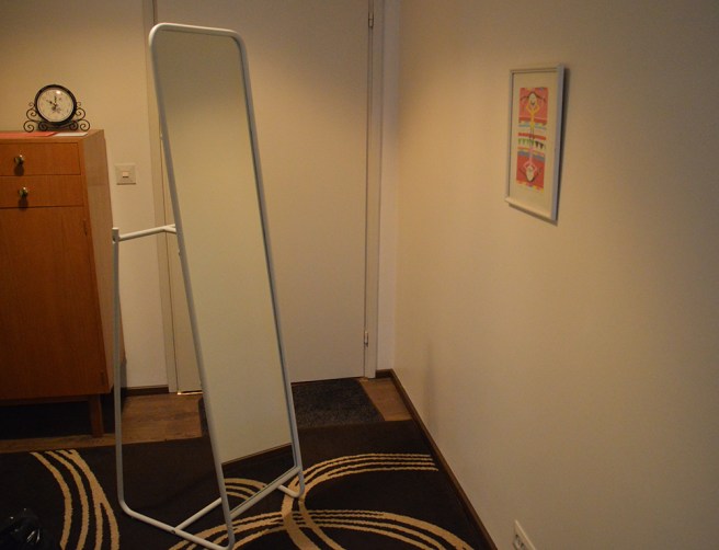 Knapper, en flyttbar spegel. Går att hänga kläder eller accessoarer på baksidan.